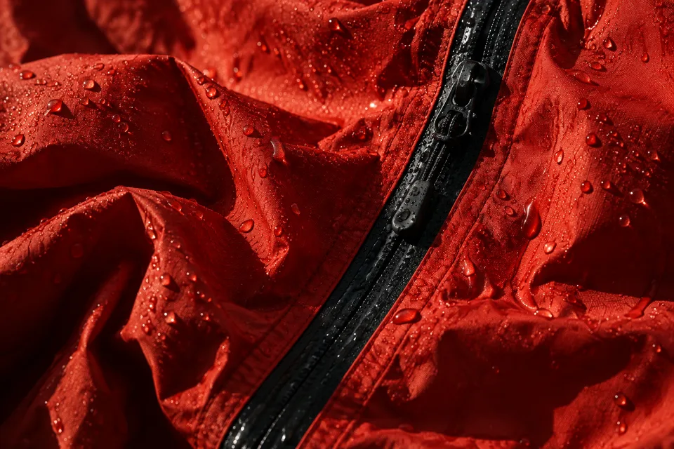 Raindrops on the red shell and its black zipper